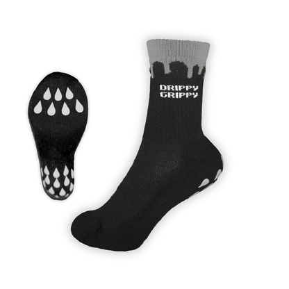 Reflective Black |  A pair of grip socks shown on a white background, with one sock upright displaying the black grip soles and white 'DRIPPY GRIPPY' text on the gray cuff, and the other sock laid flat showing the tread pattern.