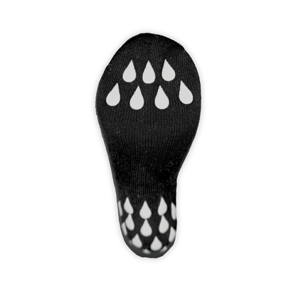 Reflective Black | A black knit sock sole with white teardrop-shaped grip dots on the top and sole, shown against a plain white background.